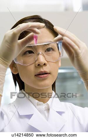 Young scientist woman looking at test tubes in laboratory, wearing a protective eyewear, front view View Large Photo Image Stock Image - Young scientist woman looking at test tubes in laboratory, wearing a protective eyewear, front view. Fotosearch