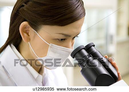 Young scientist woman looking through a Microscope in laboratory, side view, close up View Large Photo Image Stock Photography - Young scientist woman looking through a Microscope in laboratory, side view, close up. Fotosearch