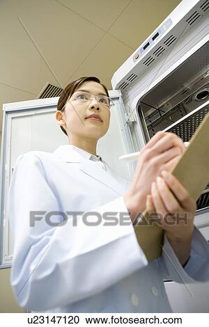 Young scientist woman writing a document in laboratory, low angle view View Large Photo Image Stock Image - Young scientist woman writing a document in laboratory, low angle view. Fotosearch