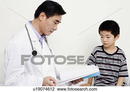 Stock Image - Close-up of a doctor looking at a medical report. Fotosearch