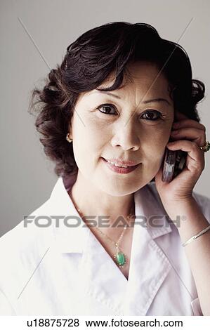 Stock Photo - Close-up of a female doctor talking on a mobile phone. Fotosearch