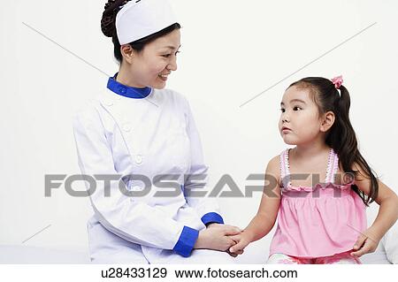 Stock Photo - Close-up of a female nurse and a girl child holding hands. Fotosearch