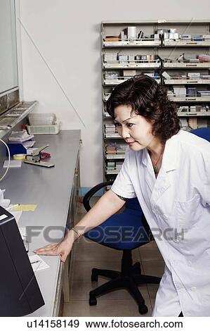 Stock Photo - Close-up of a female pharmacist in a store room. Fotosearch