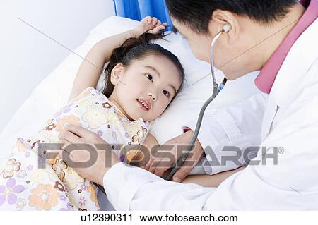 Close-up of a girl being examined by a male doctor View Large Photo Image Stock Image - Close-up of a girl being examined by a male doctor. Fotosearch