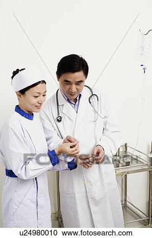 Close-up of a male doctor and female nurse discussing View Large Photo Image Stock Image - Close-up of a male doctor and female nurse discussing. Fotosearch