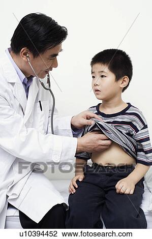 Stock Image - Close-up of a male doctor examining a child. Fotosearch