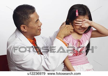 Close-up of a male doctor playing with a girl View Large Photo Image Stock Photo - Close-up of a male doctor playing with a girl. Fotosearch