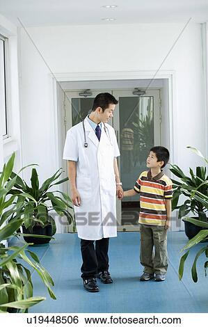 Male doctor holding a boy's hands View Large Photo Image Stock Photograph - Male doctor holding a boy's hands. Fotosearch