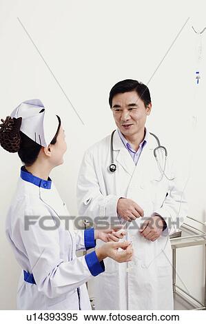 Male doctor talking to a female nurse View Large Photo Image Stock Photography - Male doctor talking to a female nurse. Fotosearch