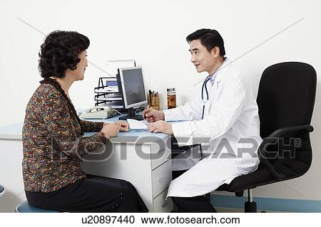 Stock Image - Male doctor talking to a patient. Fotosearch