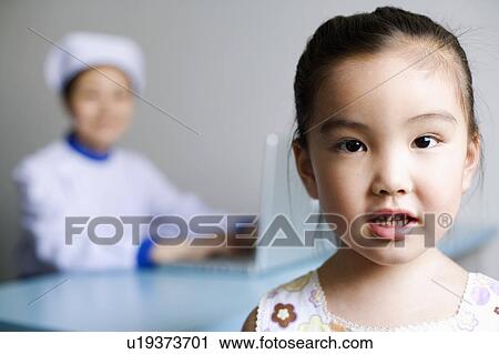 Portrait of a girl and a nurse working on a laptop in the background View Large Photo Image Stock Image - Portrait of a girl and a nurse working on a laptop in the background. Fotosearch
