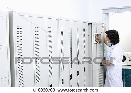 Side profile of a female looking at a mirror on the door of a locker View Large Photo Image Stock Image - Side profile of a female looking at a mirror on the door of a locker. Fotosearch
