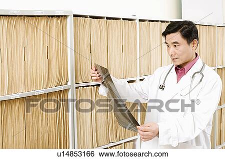 Close-up of a doctor looking an X-Ray image View Large Photo Image Stock Photograph - Close-up of a doctor looking an X-Ray image. Fotosearch