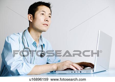 Close-up of a doctor operating a laptop View Large Photo Image Stock Photo - Close-up of a doctor operating a laptop. Fotosearch
