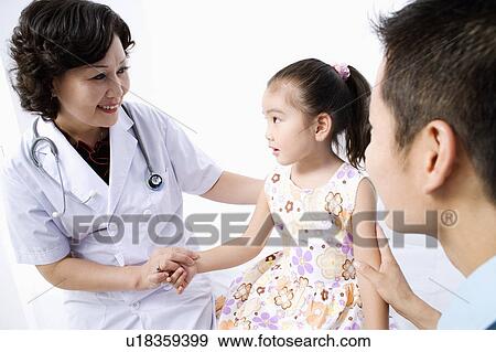 Stock Photo - Close-up of a female doctor examining a girl and smiling. Fotosearch