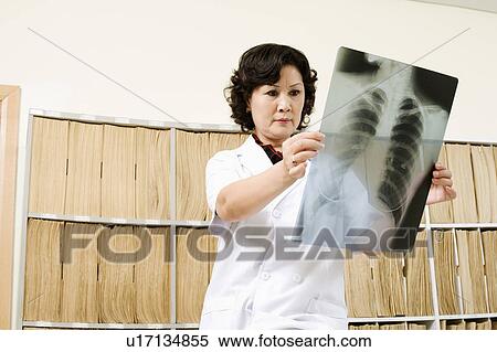 Close-up of a female doctor looking at X-Ray image View Large Photo Image Stock Photography - Close-up of a female doctor looking at X-Ray image. Fotosearch