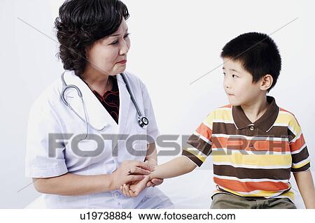 Close-up of a female doctor taking a patient's pulse View Large Photo Image Picture - Close-up of a female doctor taking a patient's pulse. Fotosearch