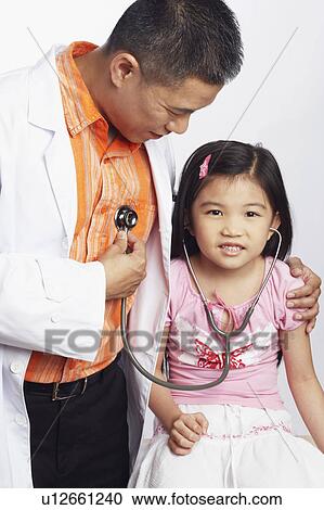 Close-up of a girl listening to a male doctors heart beat with a stethoscope View Large Photo Image Stock Image - Close-up of a girl listening to a male doctors heart beat with a stethoscope. Fotosearch