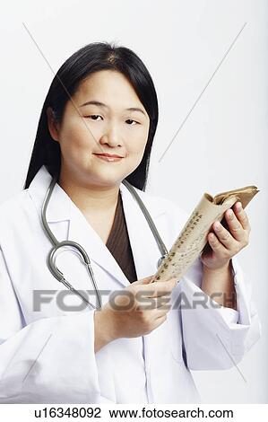 Portrait of a female doctor holding a book View Large Photo Image Stock Image - Portrait of a female doctor holding a book. Fotosearch