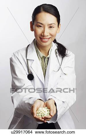Picture - Portrait of a female doctor holding tablets. Fotosearch