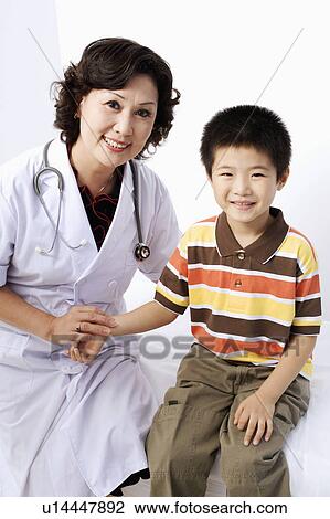 Stock Image - Portrait of a female doctor taking a patient's pulse. Fotosearch