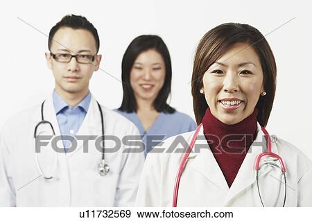 Portrait of a female doctor with a male doctor and a female nurse standing behind her View Large Photo Image Stock Photo - Portrait of a female doctor with a male doctor and a female nurse standing behind her. Fotosearch