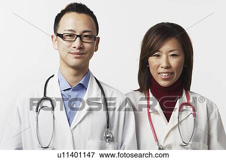 Portrait of a male and a female doctor standing side by side View Large Photo Image Stock Photo - Portrait of a male and a female doctor standing side by side. Fotosearch