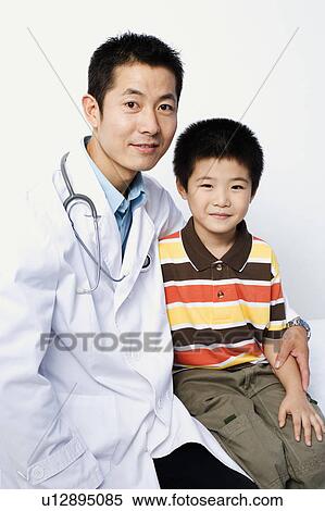 Portrait of a male doctor and a boy sitting together View Large Photo Image Stock Photography - Portrait of a male doctor and a boy sitting together. Fotosearch