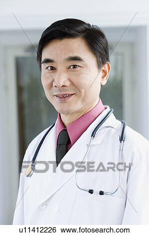 Portrait of a male doctor smiling View Large Photo Image Stock Photograph - Portrait of a male doctor smiling. Fotosearch