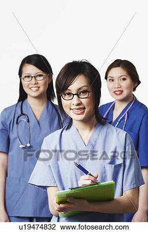 Stock Image - Portrait of three female doctors smiling. Fotosearch