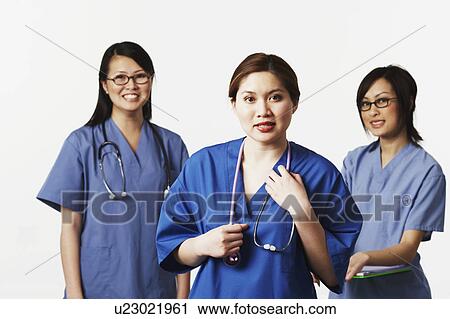 Stock Image - Portrait of three female doctors smiling. Fotosearch