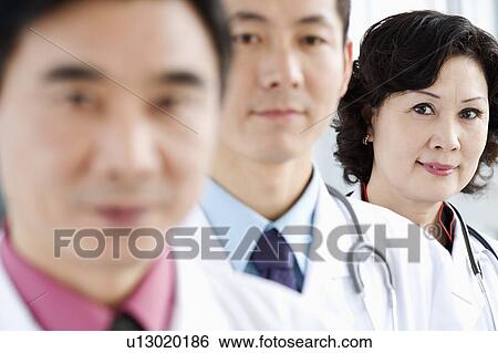 Portrait of two male doctors with a female doctor View Large Photo Image Stock Photograph - Portrait of two male doctors with a female doctor. Fotosearch