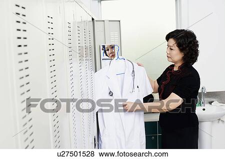 Side profile of a female doctor holding a lab coat View Large Photo Image Stock Photo - Side profile of a female doctor holding a lab coat. Fotosearch