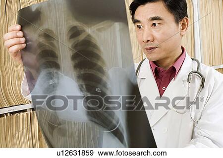 Stock Photo - Close-up of a doctor looking an X-Ray image. Fotosearch