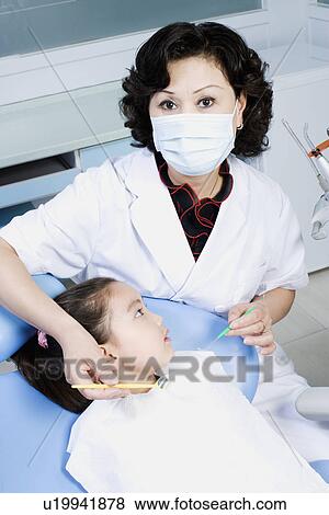 Close-up of a female dentist examining a girl's teeth View Large Photo Image Stock Photo - Close-up of a female dentist examining a girl's teeth. Fotosearch