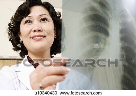 Stock Image - Close-up of a female doctor examining an X-Ray. Fotosearch
