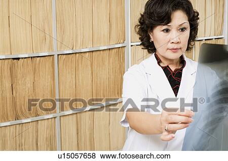 Close-up of a female doctor looking an X-Ray image View Large Photo Image Stock Photo - Close-up of a female doctor looking an X-Ray image. Fotosearch