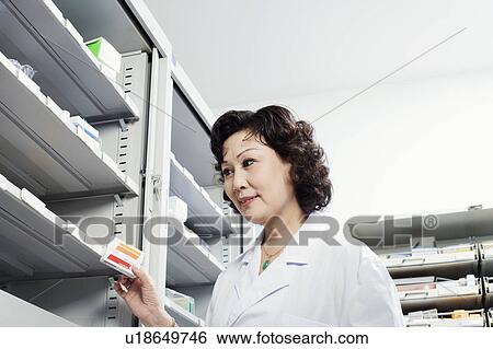 Stock Photograph - Close-up of a female pharmacist in a store room. Fotosearch