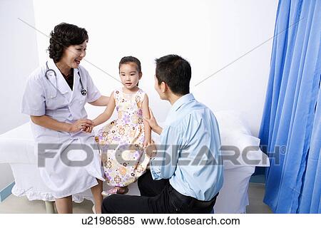 Female doctor and a young man holding a girl's hands and sitting View Large Photo Image Stock Photography - Female doctor and a young man holding a girl's hands and sitting. Fotosearch
