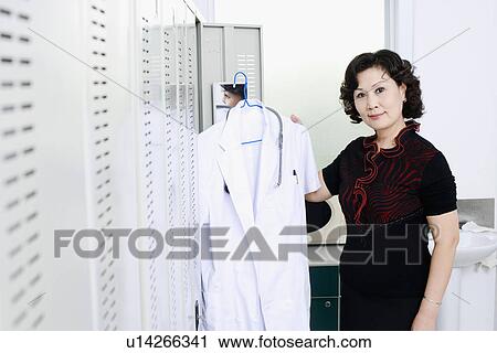 Portrait of a female doctor holding a lab coat View Large Photo Image Stock Image - Portrait of a female doctor holding a lab coat. Fotosearch