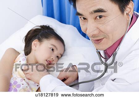 Portrait of a male doctor examining a girl View Large Photo Image Stock Photo - Portrait of a male doctor examining a girl. Fotosearch