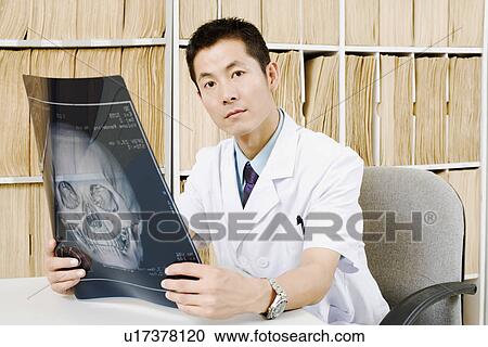 Portrait of a male doctor holding an X-Ray View Large Photo Image Stock Image - Portrait of a male doctor holding an X-Ray. Fotosearch