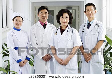 Stock Image - Portrait of three doctors and a nurse standing together. Fotosearch