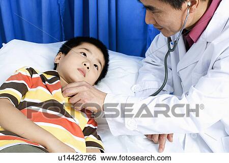 Side profile of a male doctor examining a boy with a stethoscope View Large Photo Image Stock Photograph - Side profile of a male doctor examining a boy with a stethoscope. Fotosearch