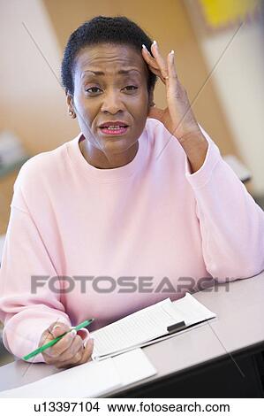 Picture - Adult student in class looking frustrated. Fotosearch
