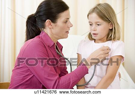 Doctor giving checkup with stethoscope to young girl in exam room View Large Photo Image Stock Photograph - Doctor giving checkup with stethoscope to young girl in exam room. Fotosearch
