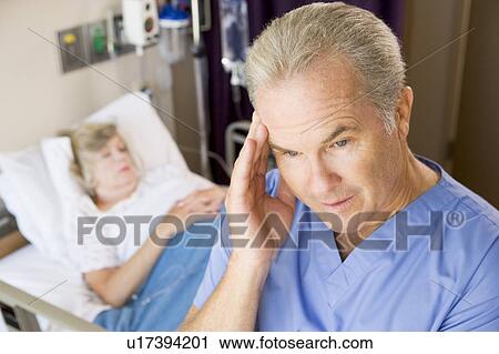 Stock Image - Doctor Standing In Patients Room, Looking Frustrated. Fotosearch