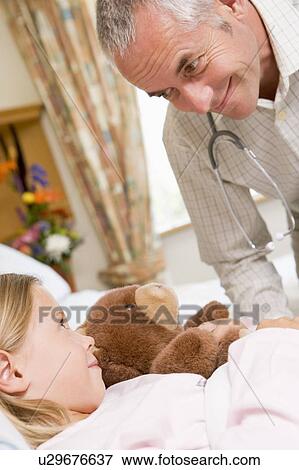 Stock Photo - Doctor Talking To His Young Patient. Fotosearch