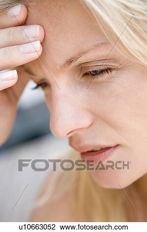 Stock Image - Head shot of woman scowling. Fotosearch
