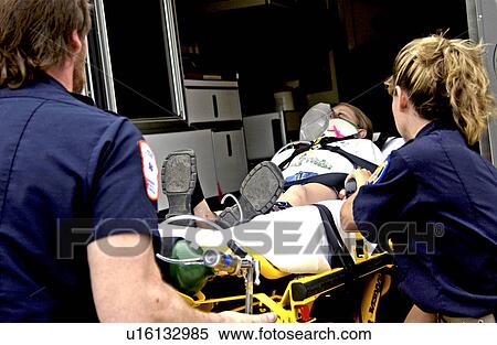 Stock Photography - EMTs loading patient into ambulance. Fotosearch